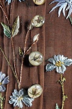 some flowers and buttons on a brown cloth