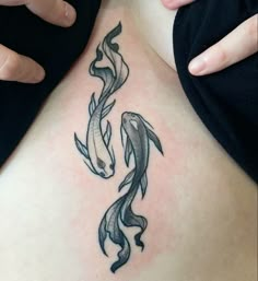 a woman with a tattoo on her chest has two koi fish swimming in the water