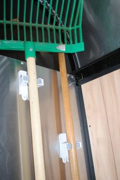 a close up of a green rack on top of a metal door with wooden handles