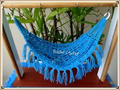 a blue hammock hanging from a wooden frame next to a potted plant