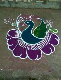 a peacock painted on the ground next to a brick wall