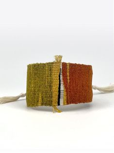 two pieces of woven material with tassels on each side, one orange and the other yellow