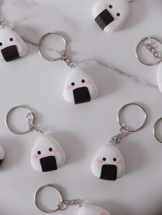 several key chains with faces on them sitting next to each other in front of a marble surface