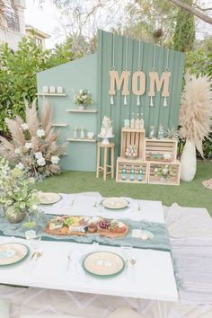 a table set up for a baby's first birthday party with plates and cups on it