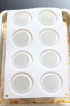 an empty white tray filled with cupcakes on top of a table