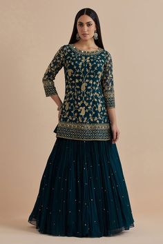 Teal blue kurta with all over paisley and floral embroidery in sequins and zari work. Paired with a lehenga and dupatta.
Components: 3
Pattern: Embroidery
Type Of Work: Floral, Paisley
Neckline: Round Neck
Sleeve Type: Three Quarter Sleeves
Fabric: Goergette, Net
Color: Blue
Other Details: 
Scallop, sequin embroidered border dupatta

Occasion: Sangeet - Aza Fashions Festive Sharara With Self Design For Reception, Traditional Blue Lehenga With Straight Kurta, Diwali Georgette Lehenga With Straight Kurta, Diwali Lehenga In Georgette, Fitted Blue Sharara For Reception, Georgette Sharara With Self Design For Reception, Reception Sharara With Self Design In Georgette, Blue Georgette Sets For Transitional Season, Blue Fitted Lehenga For Transitional Season