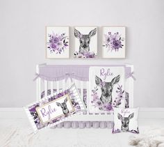 a baby crib bedding set with purple flowers and deer prints on the wall