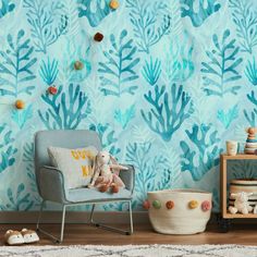 a room with a chair, rug and wallpaper that has blue plants on it