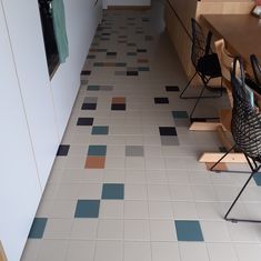 an empty room with chairs and tables on the floor in front of a counter top