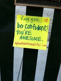 a sign posted on a fence that says, hey you be confident you're awesome