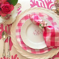 a pink and white place setting with flowers