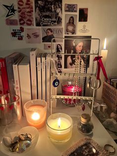 a table topped with candles and pictures next to other items on top of the table