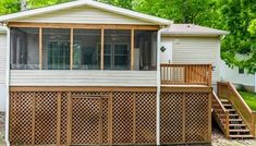 a small house with a deck in the front yard