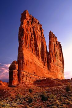 the rock formations in the desert are very tall and have large rocks on each side