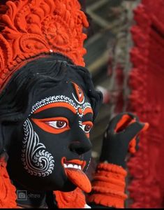 a close up of a face painted in black and orange