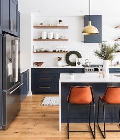 two orange chairs sit in front of the kitchen island