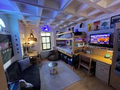 a room with bunk beds, desks and other items in it that are lit up