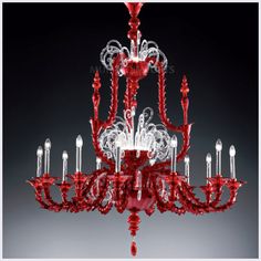 a red chandelier hanging from the ceiling with many lights on top of it