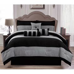 a bed with black and grey comforters in a room