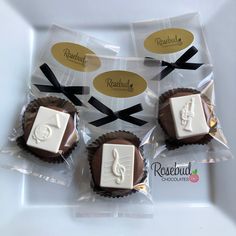 four chocolates wrapped in cellophane and tied with black ribbon