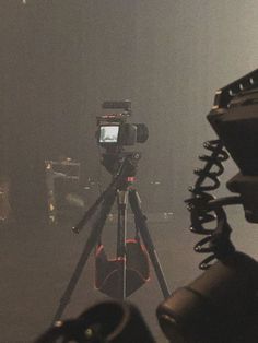 a camera is set up on a tripod in front of a stage with microphones