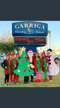 group of children dressed up in christmas costumes standing next to a sign for garriga elementary