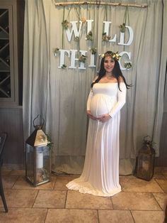 a pregnant woman standing in front of a backdrop