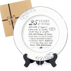 a 25th anniversary plate with a gift box in the back and a card on top