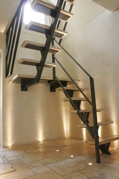 a stair case with lights on the side and steps up to the second floor in an empty room