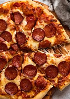 a pepperoni pizza cut into four slices on a cutting board