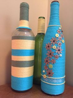 two vases with flowers on them sitting next to each other