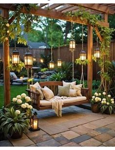 a wooden bench sitting under a pergoline covered arbor with hanging lights and potted plants