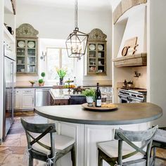 a kitchen with two stools and a center island in the middle of the room