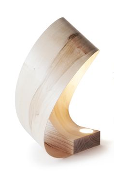 a wooden object that is sitting on top of a white surface with light coming from it