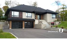 a two story house with black garage doors