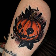 a tattoo with a pumpkin on it and a dog's face in the center