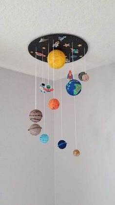 a mobile with planets hanging from it's ceiling in a child's room