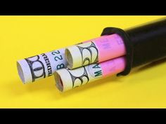 two rolls of pink and white paper on top of a black tube with the word boss printed on it