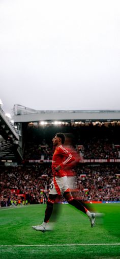 a soccer player is running on the field in front of an empty stadium full of people