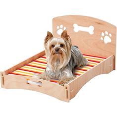 a small dog laying on top of a wooden bed