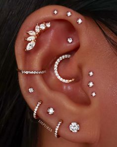 a woman's ear with three different piercings on it, including an ear cuff and