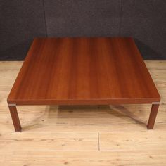 a square wooden table sitting on top of a hard wood floor