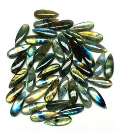 several different types of glass beads on a white surface with blue, yellow and green colors