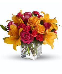 a vase filled with lots of different colored flowers