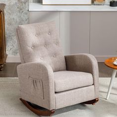 a beige rocking chair with buttons on the armrests in a living room setting