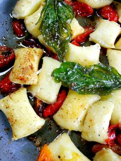 pasta with spinach, tomatoes and cheese on a blue plate