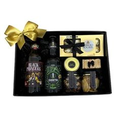 an assortment of liquors and snacks in a black gift box with a yellow bow