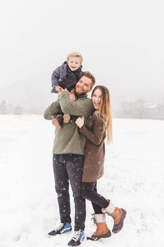 a man, woman and child are standing in the snow with their arms around each other