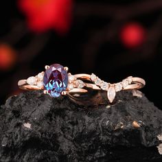 an engagement ring with a blue stone surrounded by white diamonds on top of a rock