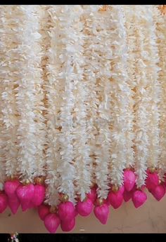 white and pink flowers hanging from the ceiling